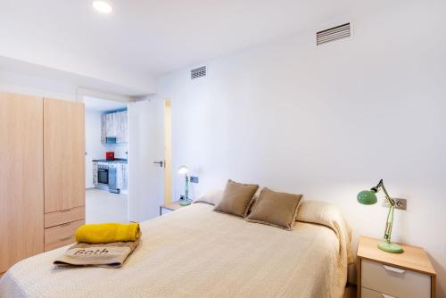 ein Schlafzimmer mit einem Bett und einem gelben Handtuch darauf in der Unterkunft Beach Pearl Cala de Mijas in Mijas