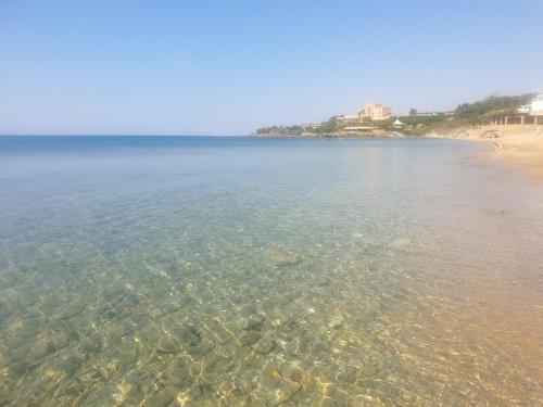 Suite Bice In Villaggio Seleno في Ovile la Marinella: اطلالة على شاطئ فيه صخور في الماء