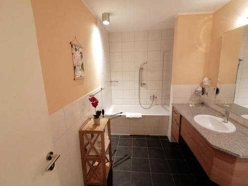 ein Badezimmer mit einer Badewanne, einem Waschbecken und einer Badewanne in der Unterkunft Hotel Villa Passion in Malchow