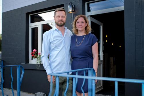 a man and a woman standing outside of a house at Hotel & Restaurant Maison Pal'Ange in Durbuy