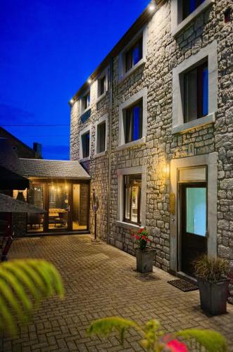 a large stone building with a courtyard at night at Hotel & Restaurant Maison Pal'Ange in Durbuy