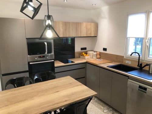 une cuisine avec un évier et une cuisinière four supérieur dans l'établissement Jolie villa à Grasse quartier Saint Antoine, à Grasse