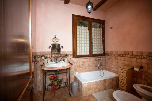 uma casa de banho com um lavatório, uma banheira e um WC. em Katia Loreti em Capodacqua di Foligno