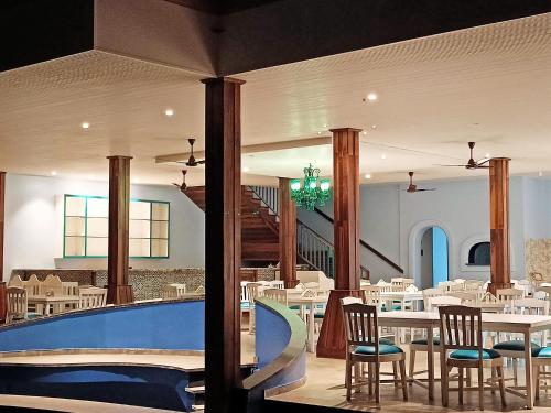 un restaurante con piscina, mesas y sillas en Resort Terra Paraiso, en Calangute