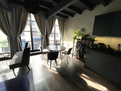 a living room with a table and chairs and a tv at Hotel de Prince in Nijmegen