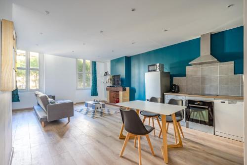 une cuisine avec une table et des chaises dans une pièce dans l'établissement Blue Appartement Spacieux 3 chambres, à Marseille