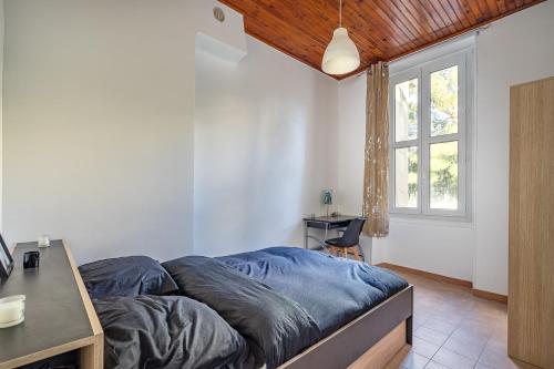 une chambre avec un lit, un bureau et une fenêtre dans l'établissement Blue Appartement Spacieux 3 chambres, à Marseille