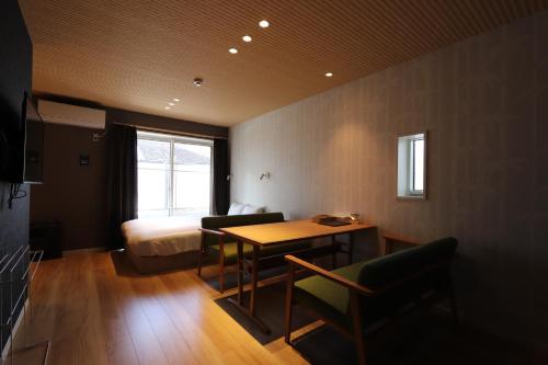 a room with a bed and a table and chairs at 5 minutes Shin-Osaka 9 in Osaka