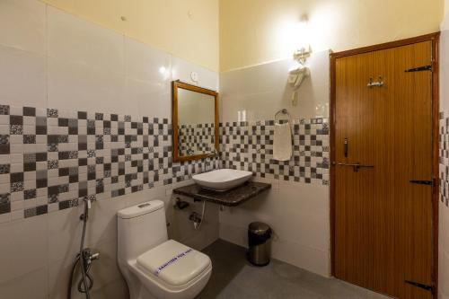 een badkamer met een toilet en een wastafel bij KSTDC Hotel Mayura Chalukya, Badami in Badami