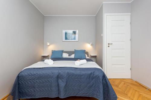 - une chambre avec un lit bleu et des serviettes dans l'établissement Apartment Warsaw Kredytowa by Renters, à Varsovie