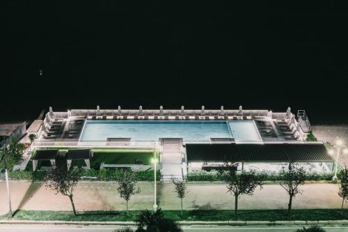 a large building with a swimming pool at night at Hotel La Palma in Stresa