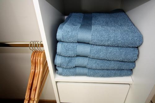 una pila de toallas azules en un estante en un armario en Appart'hôtel Le Pin, en La Tour-du-Pin