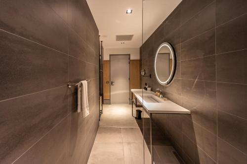 een badkamer met een wastafel en een spiegel bij Notiz Hotel Leeuwarden in Leeuwarden