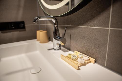 a bathroom sink with a faucet and a mirror at Notiz Hotel Leeuwarden in Leeuwarden