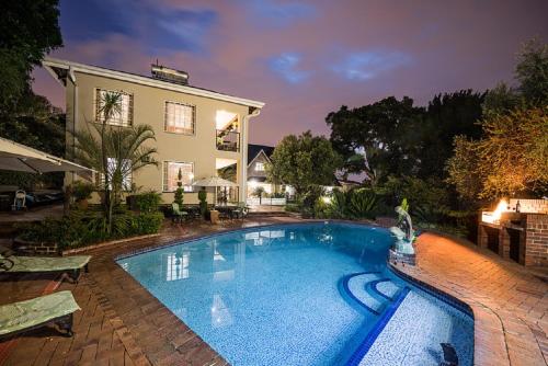 a large swimming pool in front of a house at Gallo Manor Executive Bed & Breakfast in Johannesburg