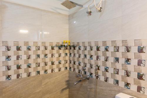 a bathroom with a shower with a sink at KSTDC Hotel Mayura Velapuri Belur in Belūr