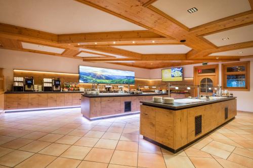 ヴァークラインにあるApparthotel Markushofの木製の天井と大画面スクリーンが備わる広いキッチン
