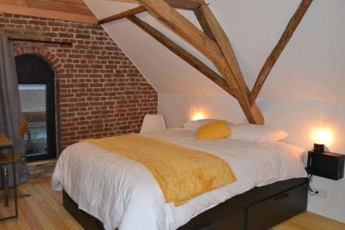 a bedroom with a large bed with a brick wall at Albecca 