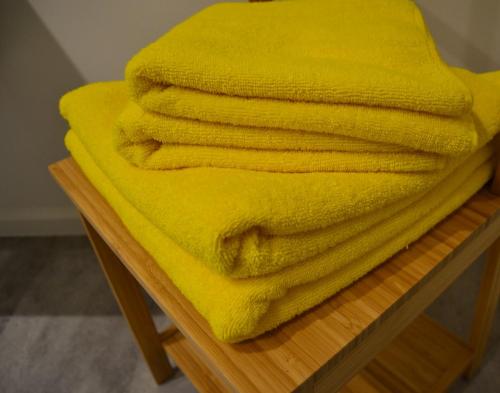 una pila de toallas amarillas sentadas en una mesa en Albecca 