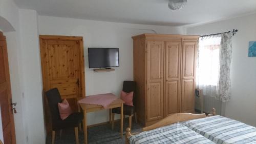 1 dormitorio con 1 cama, escritorio y TV en Ferienwohnung Karl, en Nussdorf am Inn