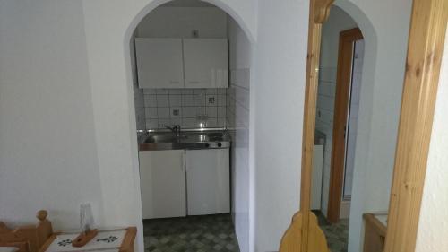 un arco que conduce a una cocina con fregadero en Ferienwohnung Karl, en Nussdorf am Inn