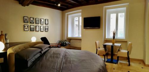 um quarto com uma cama, uma mesa e uma televisão em Atelier Musicale Suites em Roma