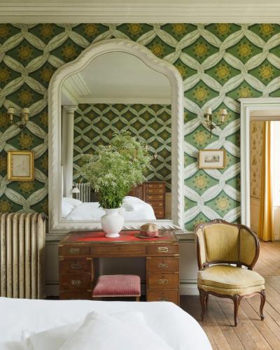 - une chambre avec un miroir, une commode et une chaise dans l'établissement Château de Martigny, à Colmey