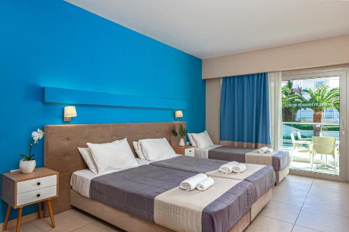 a bedroom with a large bed and a large window at Poseidon Beach Hotel in Laganas