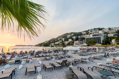 a beach with chairs and a crowd of people at Hotel Dubrovnik in Dubrovnik