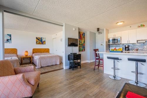 a living room with a bed and a kitchen at Pool & Jacuzzis, Free Parking, WiFi, AC, Comfy Beds, BBQ, and Great View in Honolulu