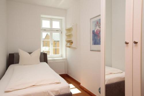 ヴストロにあるGästehaus Schimmel´sのベッドルーム1室(ベッド1台、窓、鏡付)
