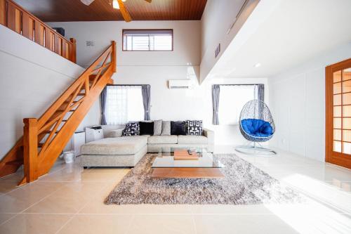 a living room with a couch and a staircase at ITOMAN SEA pension OHDO #MIM in Ōdo