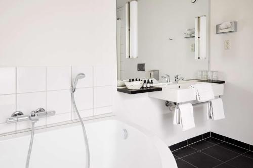 a white bathroom with a sink and a shower at Best Western ToRVEhallerne in Vejle