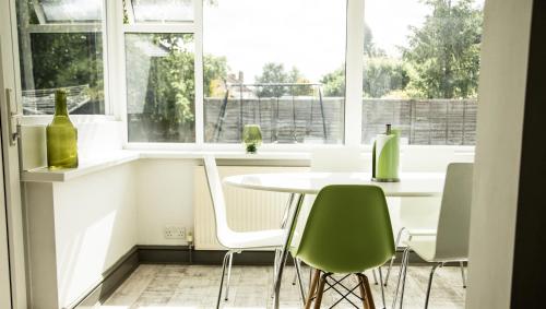 a kitchen with a table and chairs and windows at The Tushmore in Crawley