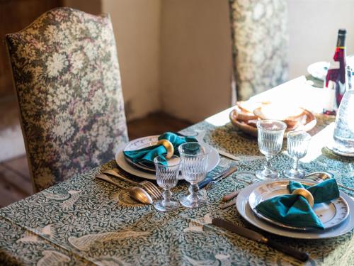 a table with plates and wine glasses on a table at Château des Marcilly Talaru in Chalmazel