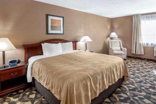 a hotel room with a large bed and a chair at Quality Inn Paradise Creek in Pullman
