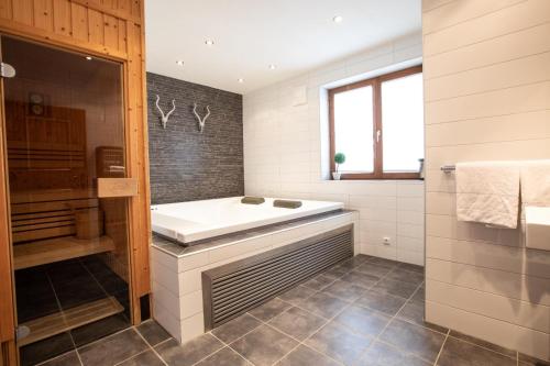 a bathroom with a bath tub and a shower at Chalet Hochkrimml 49 in Nothdorf