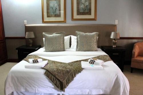 a hotel room with two beds with towels on them at Prinshof Manor Guesthouse in Pretoria