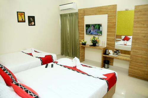 a hotel room with two beds and a mirror at Apollo Court (Apollo hospital,Sankara natralya, US consulate in Chennai