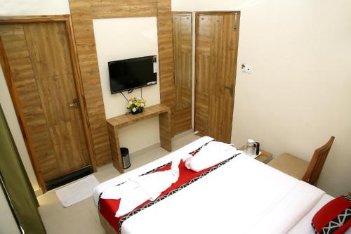 a bedroom with a bed and a tv on the wall at Apollo Court (Apollo hospital,Sankara natralya, US consulate in Chennai