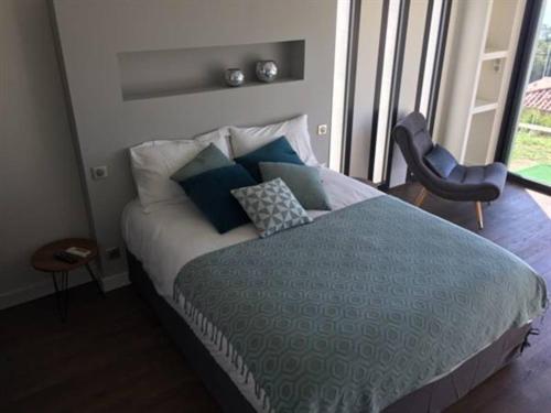 a bedroom with a bed with blue and white pillows at Maison d'hôtes Bastia in Bastia