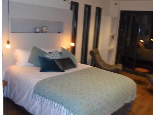 a bedroom with a large bed and a chair at Maison d'hôtes Bastia in Bastia
