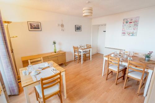 a dining room with wooden tables and chairs at Broadford House Skye in Broadford