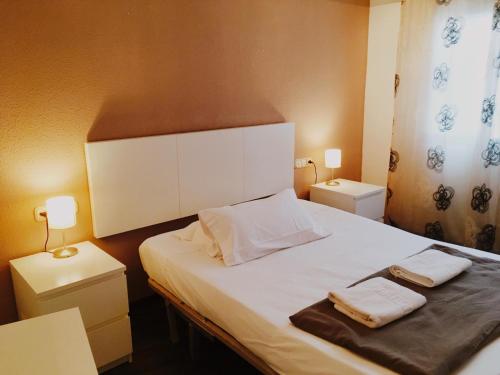a bedroom with a white bed with two towels on it at Ayuntamiento Silence in Valencia