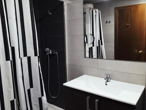 a bathroom with a sink and a shower with a mirror at Coroa Ayuntamiento in Valencia