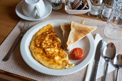 a white plate with eggs and toast and a tomato at Broadford House Skye in Broadford