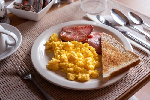 a plate of breakfast food with eggs bacon and toast at Broadford House Skye in Broadford