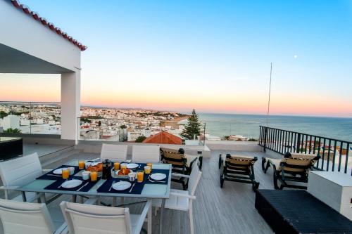 un tavolo e sedie su un balcone con vista sull'oceano di Infinito penthouse Luxury Best terrace Albufeira ad Albufeira