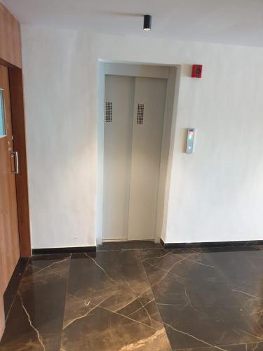 an empty room with two doors and a tile floor at Nova Park in Rajkot