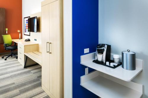 a room with a blue wall with a coffee maker on a shelf at Holiday Inn Express & Suites - Bend South by IHG in Bend